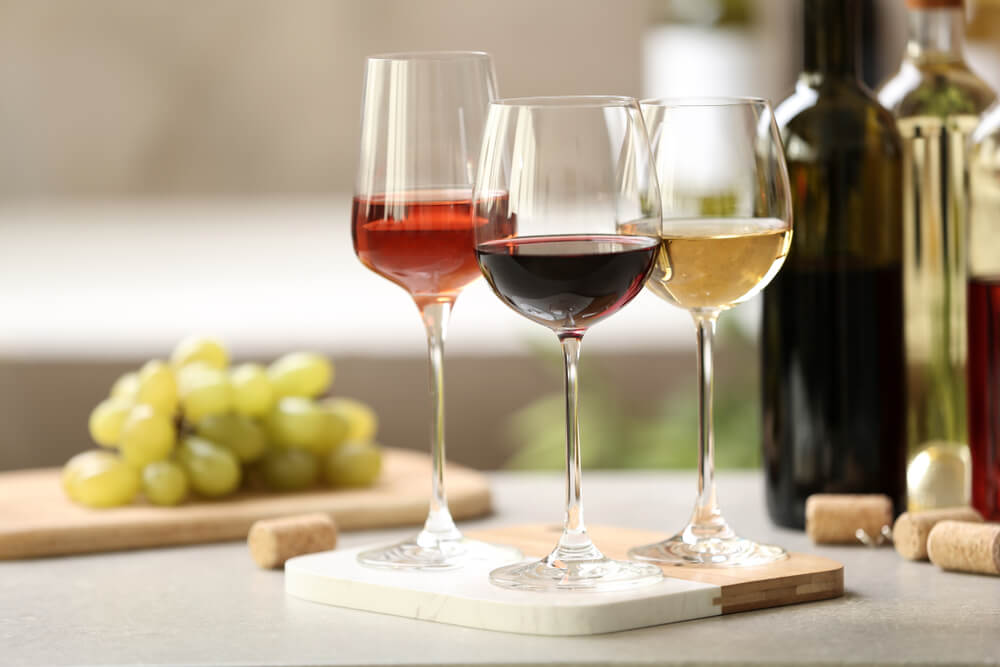 three glasses of wine, each a different color and age