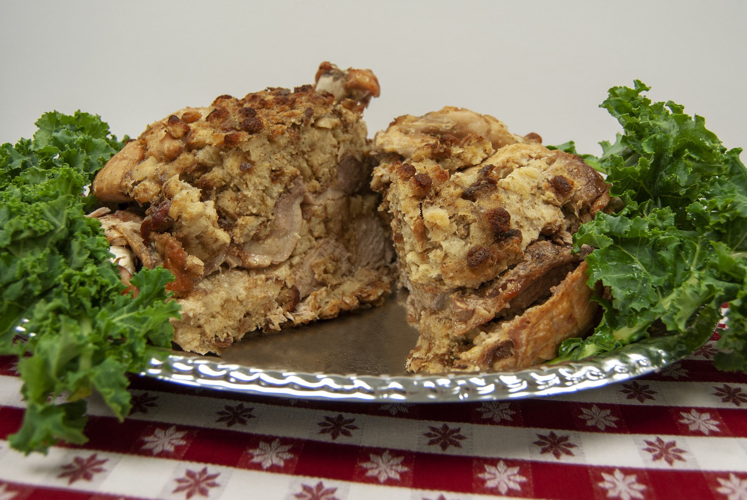 Turducken on a silver plate with lettuce on the sides.