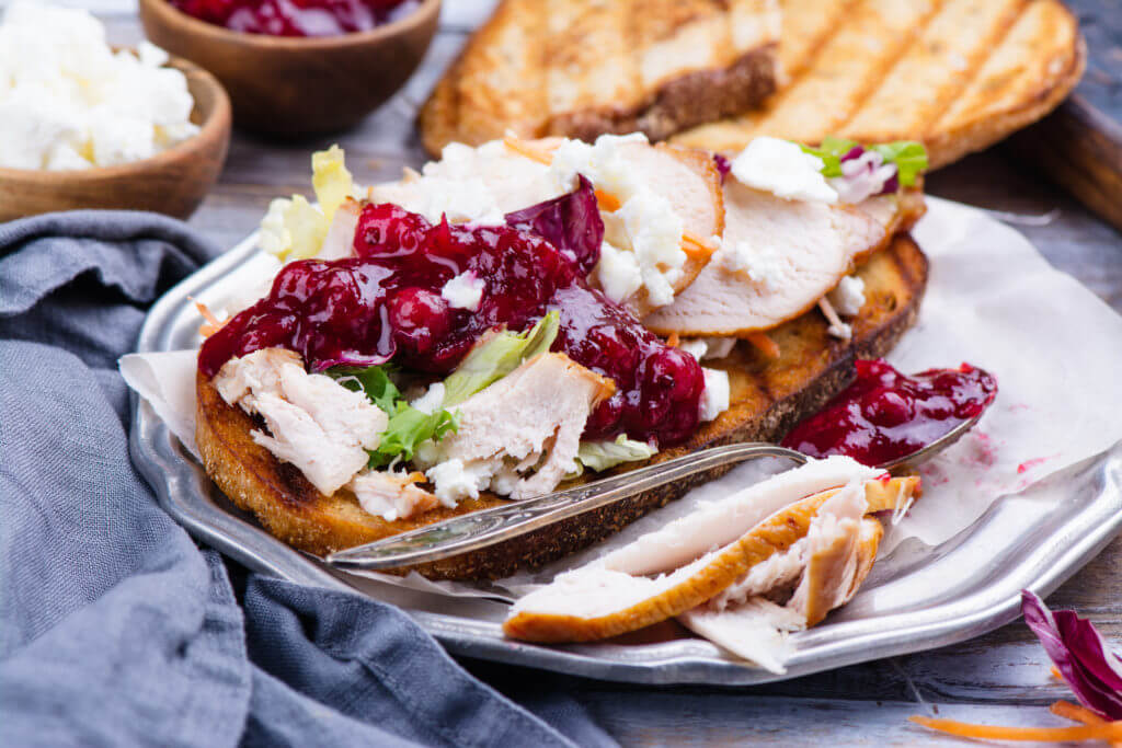 Homemade Thanksgiving leftovers sandwich with turkey, cranberry sauce