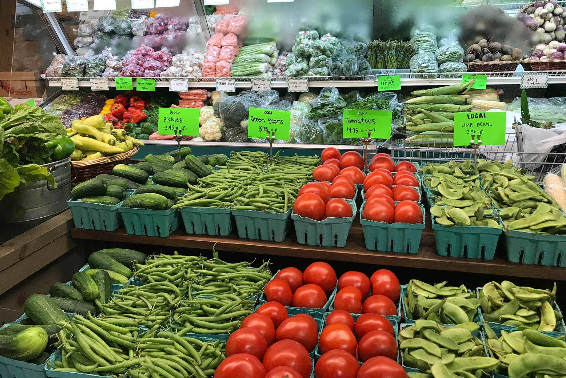 Local vegetables in season, including pickles, green beans, tomatoes, and lima beans at Glick's Produce