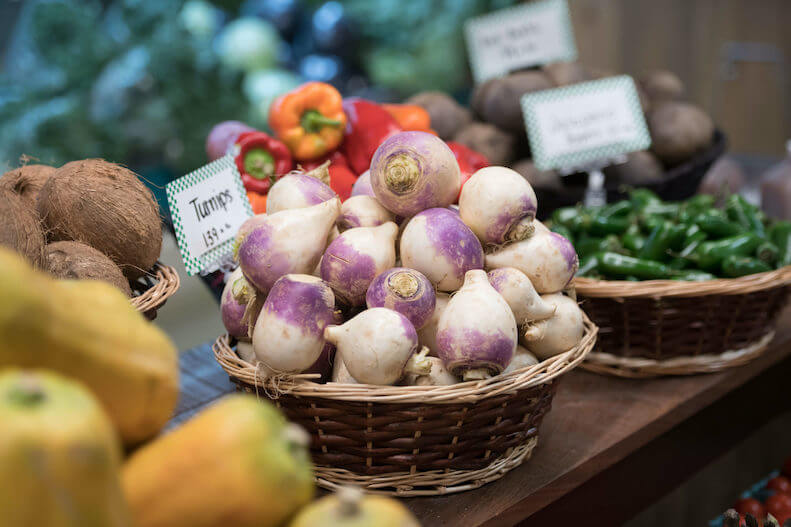 Fresh turnips in a basket at a farmers market stand