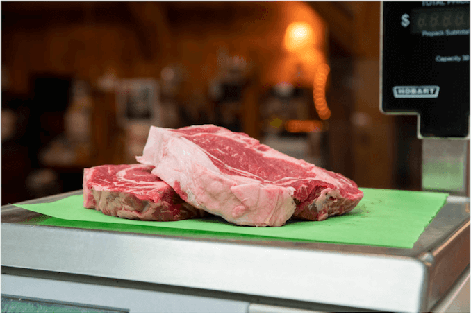 Two steaks are weighed on a butchers scale