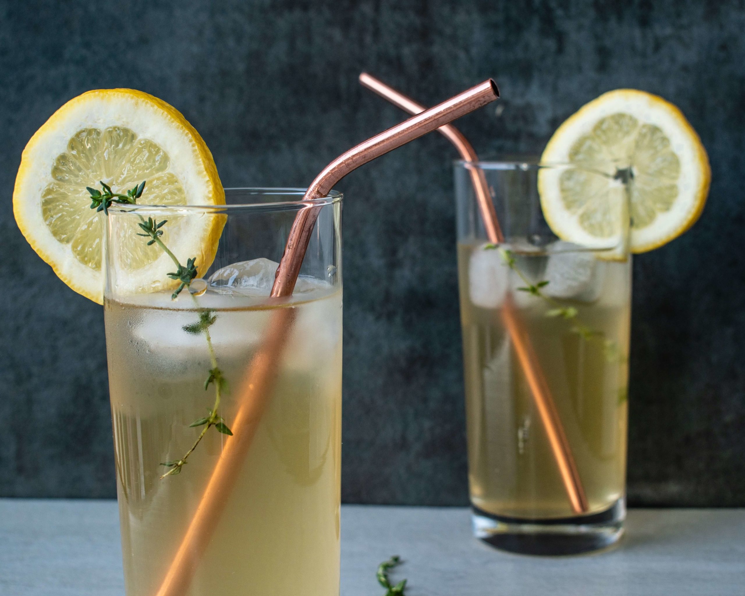 Two glasses of Amish Meadow Tea with cooper straws and lemon slices