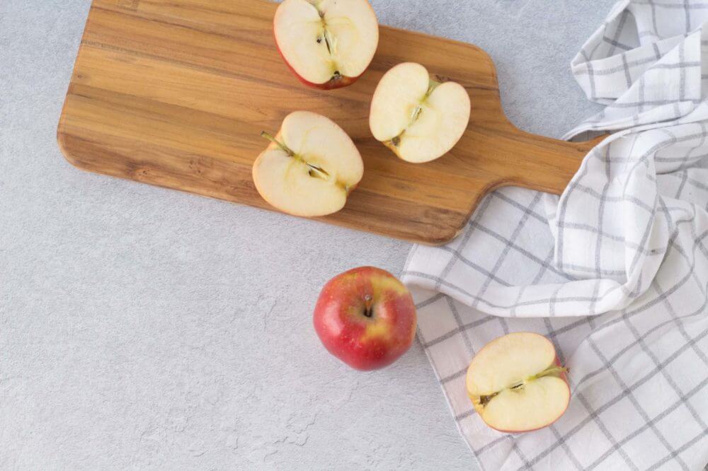 Freshly cut apples on a cutting board.