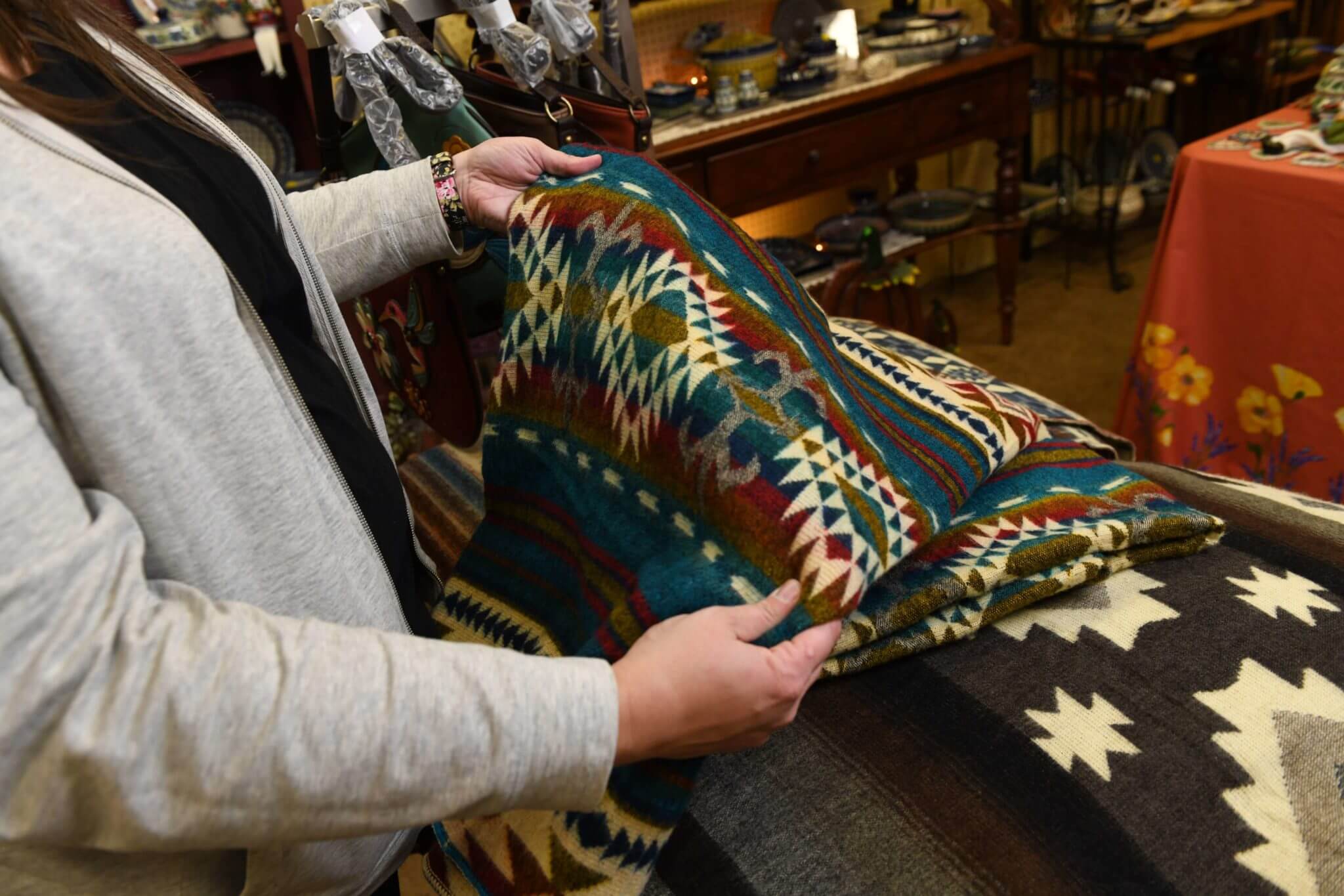 A shopper examines a real alpaca wool blanket.