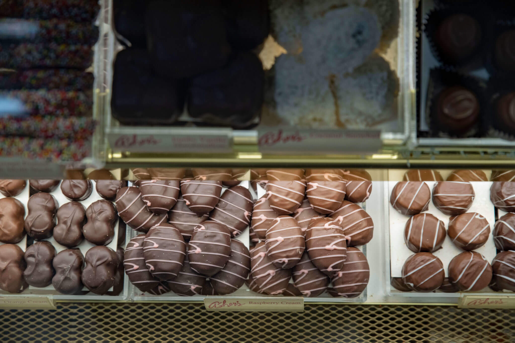 Fresh chocolates displayed in a candy case at The Markets.