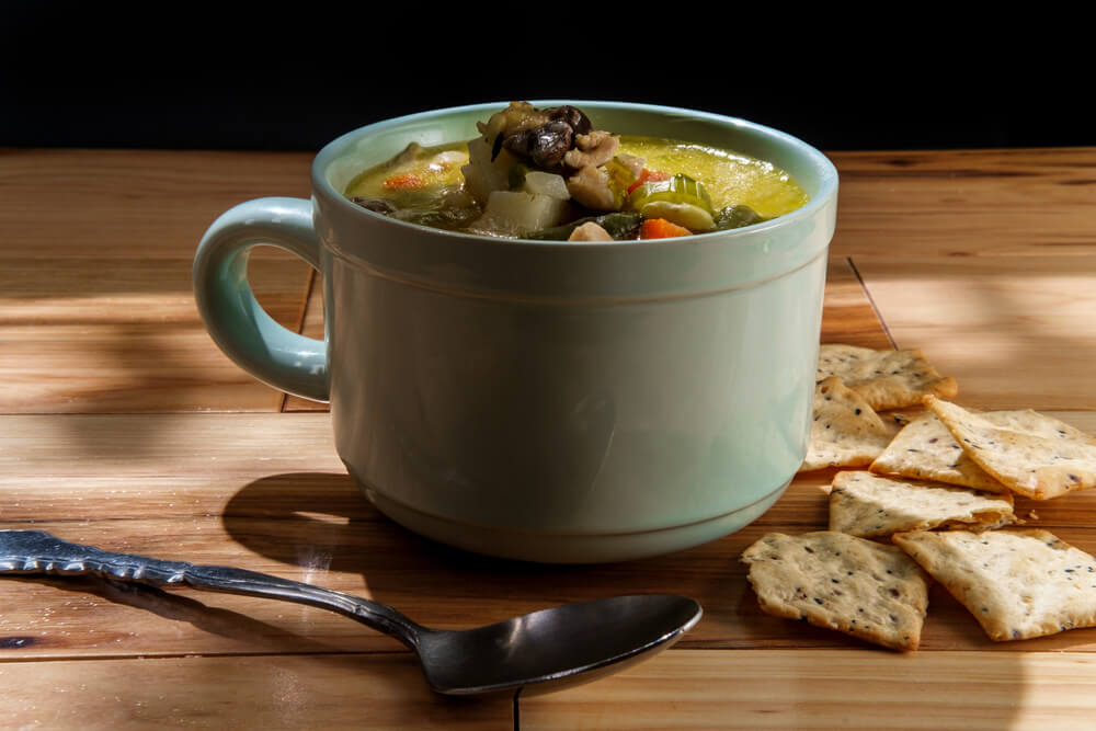 A cup of PA Dutch chicken pot pie sits on a table.