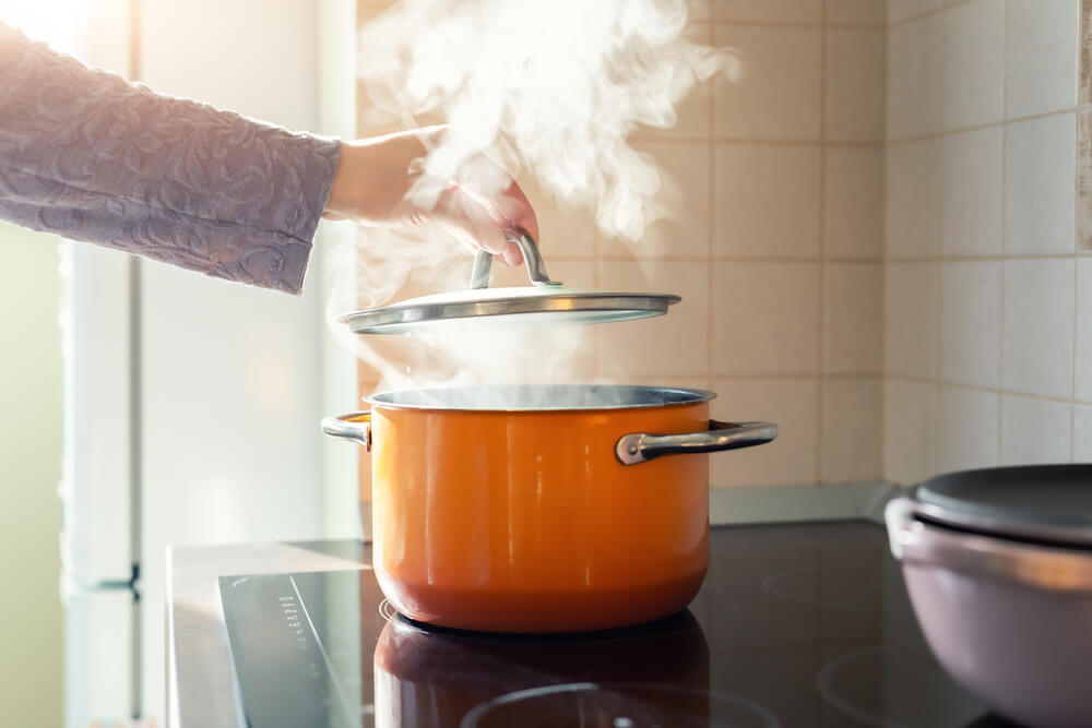 A woman makes PA Dutch chicken pot pie on her stove.