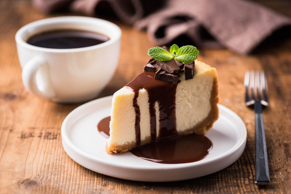 A plate of Bailey's Irish cream cheesecake with chocolate sauce.