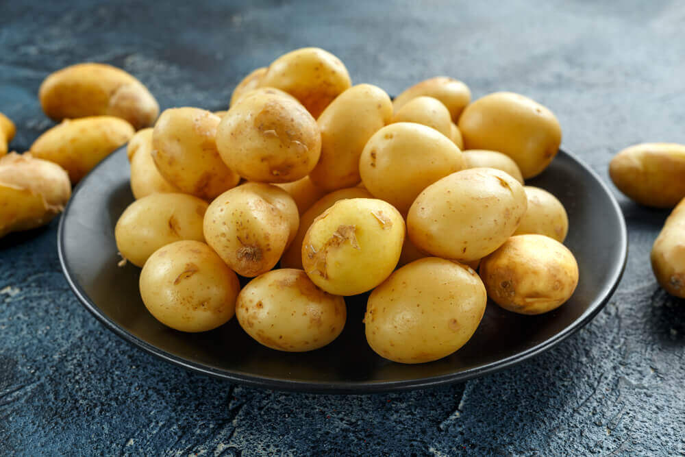 Plate of uncooked petite potatoes