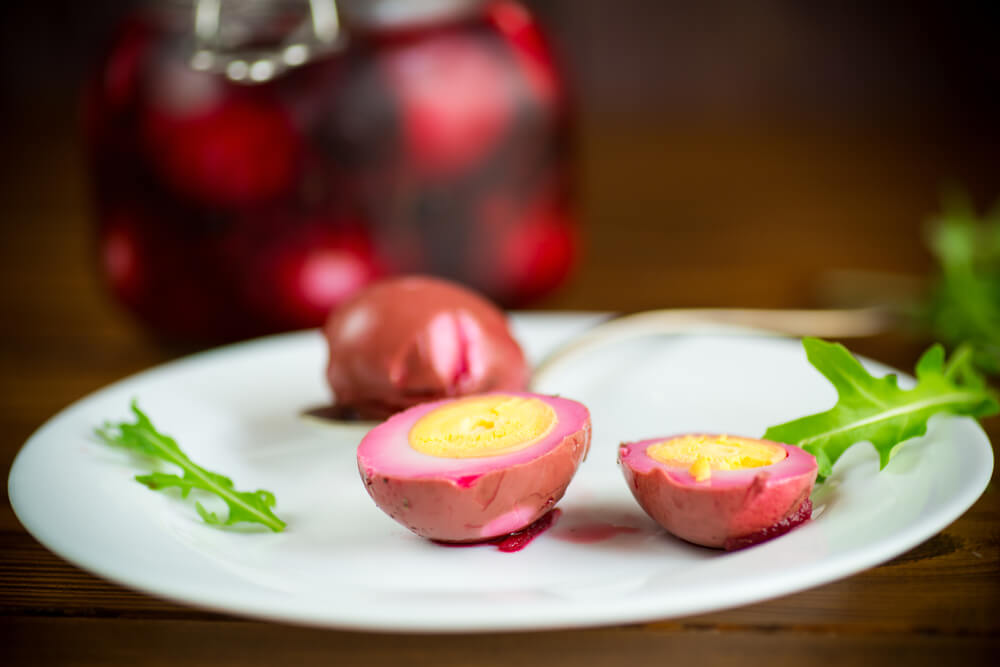 Pickled Red Beet Eggs with Argula on plate