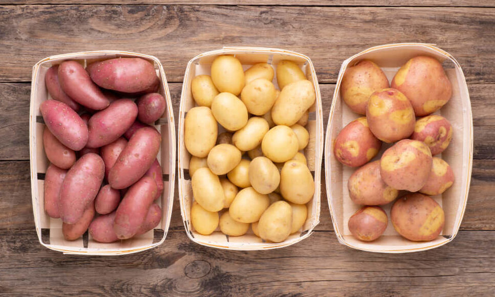 three baskets of different colored potatoes