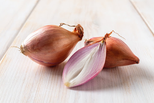 two whole shallots with a halved shallot