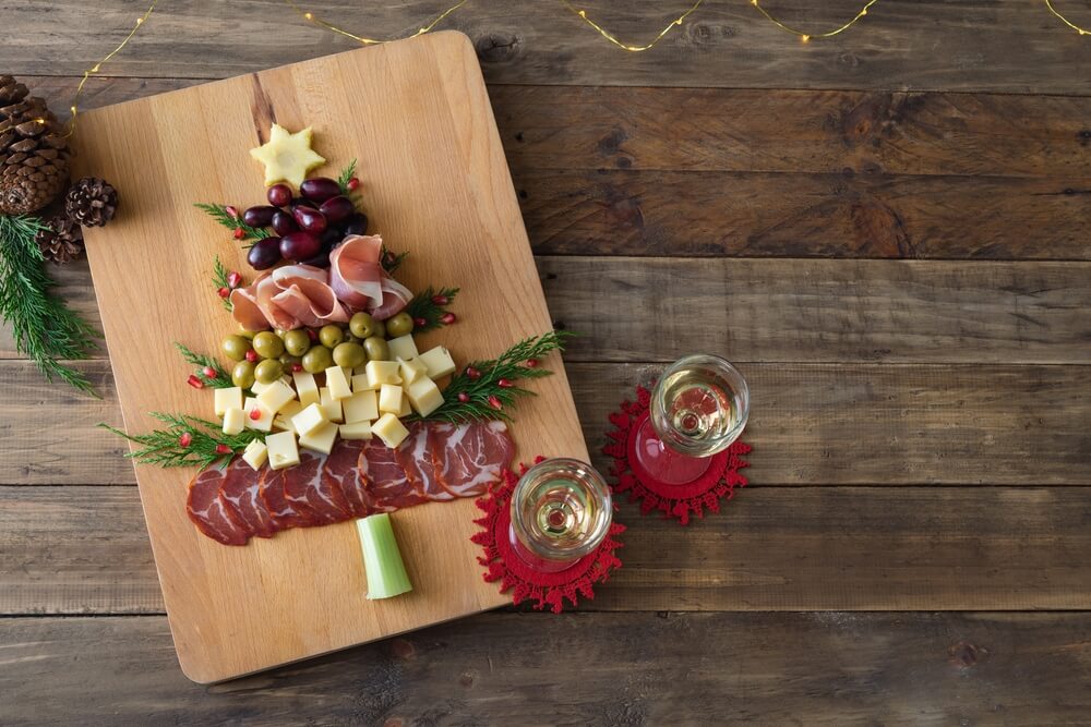 a charcuterie board with the meats, cheeses, olives, and vegetables shaped like a Christmas tree