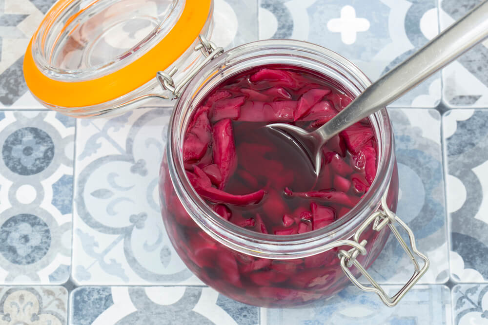 a birds-eye view of a jar of quick pickled cabbage with a spoon ready to scoop some out