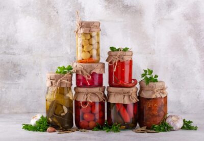 several jars of quick pickled vegetables sitting in front of a blurred background