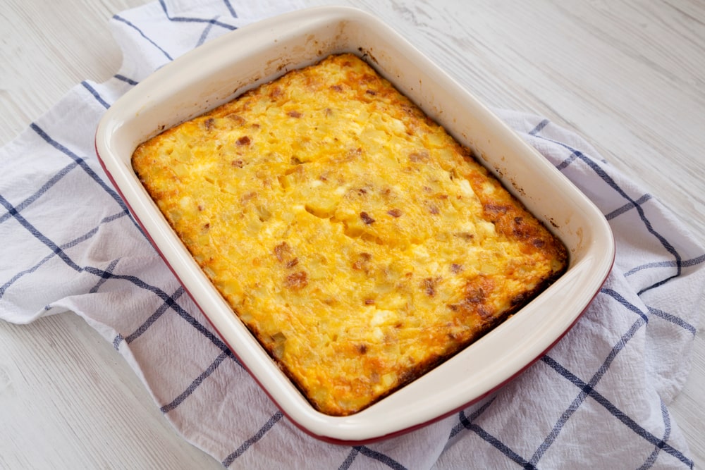 Close-up of a cheesy Amish breakfast casserole in a white dish.