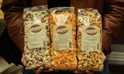 Three different flavors of Amish County tours popcorn, including milk chocolate, sweet cheddar, and caramel.