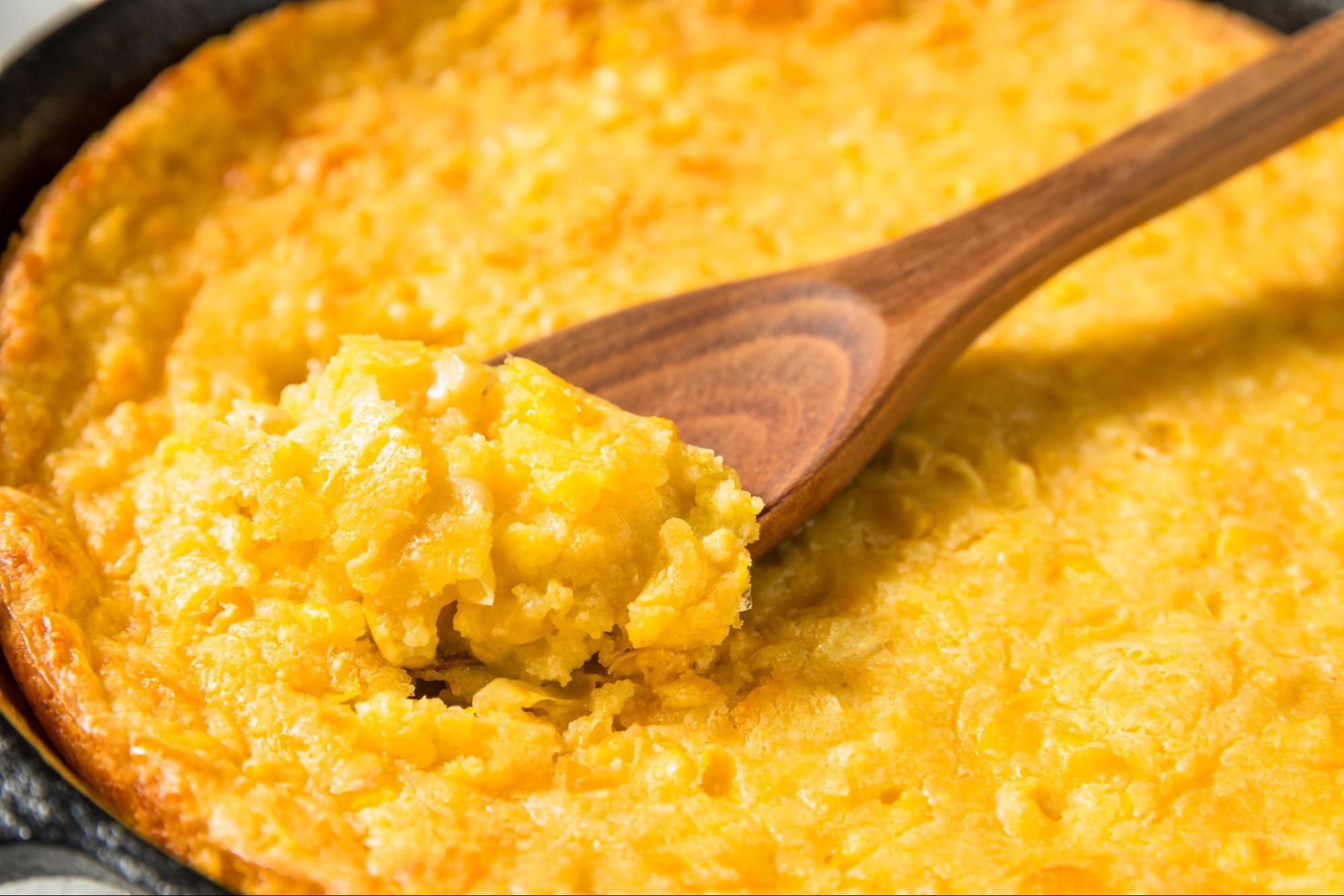 Skillet filled with golden, creamy corn pudding, highlighting easy meals for large family gatherings on a budget